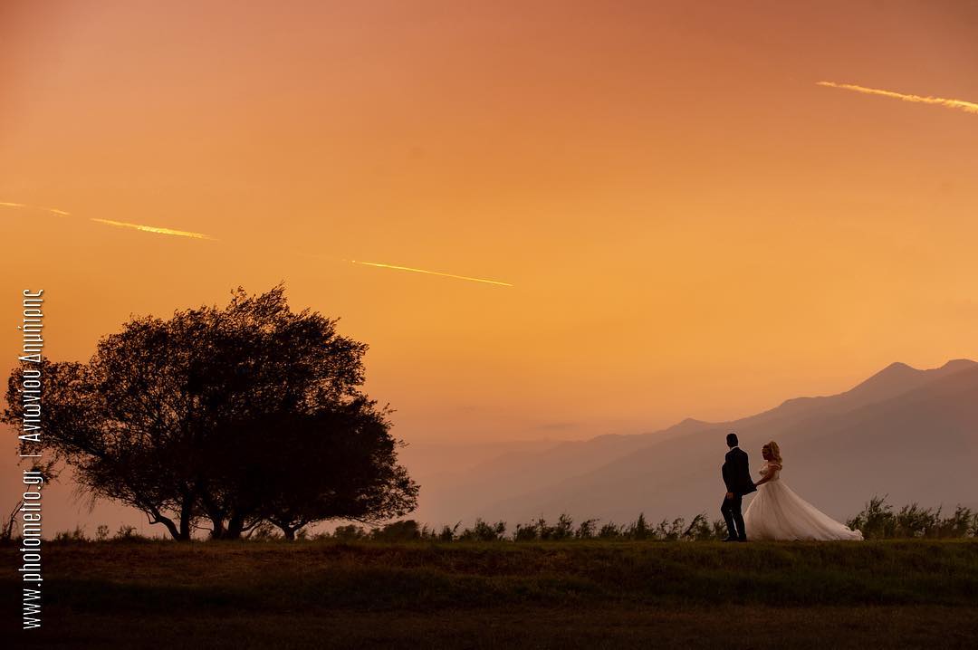 Bride and groom silhouette walking at sunset