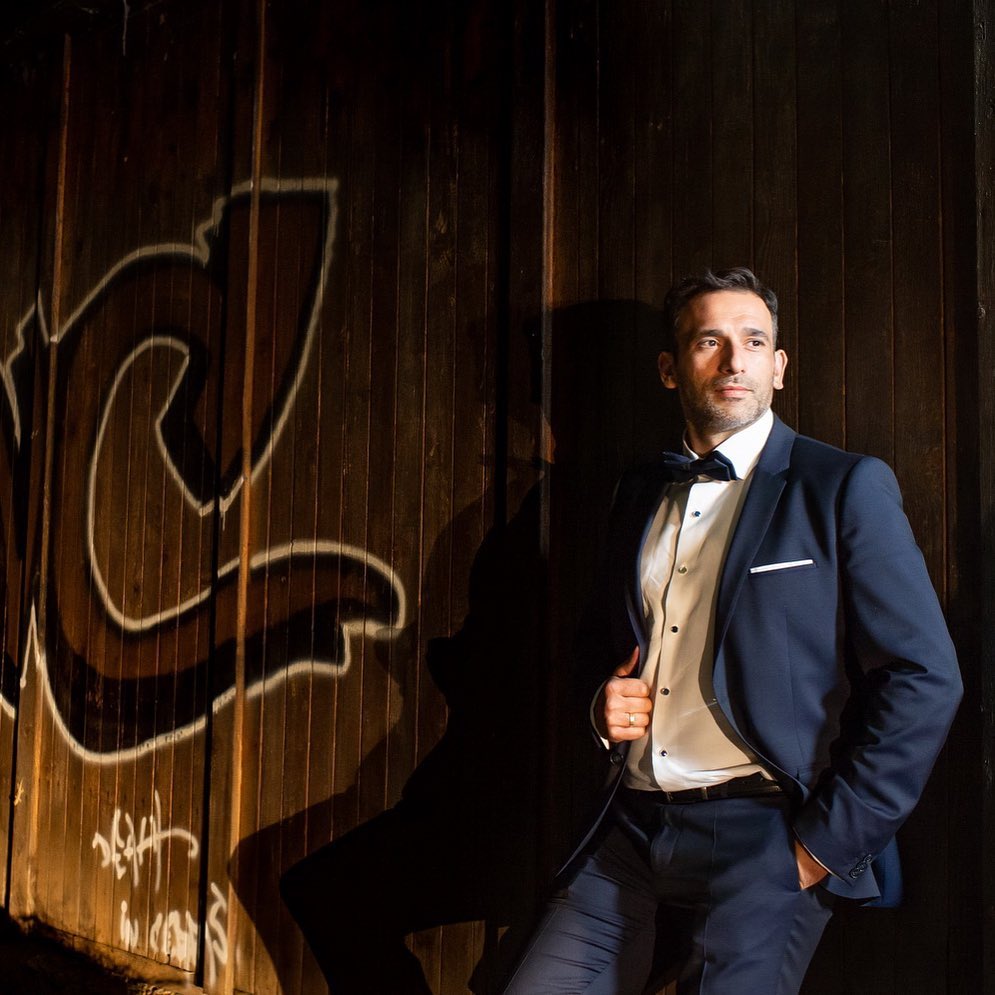 Editorial-style portrait against a rustic wall